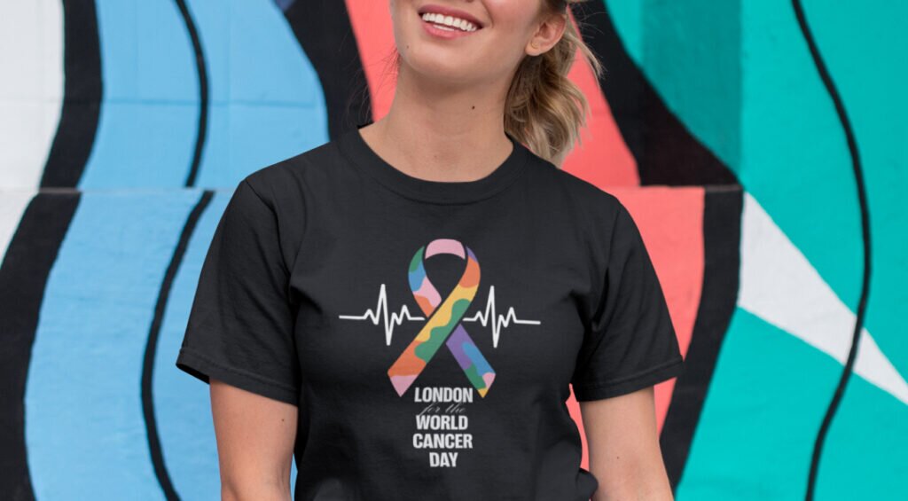 A woman in a rainbow t-shirt that reads “world cancer day”