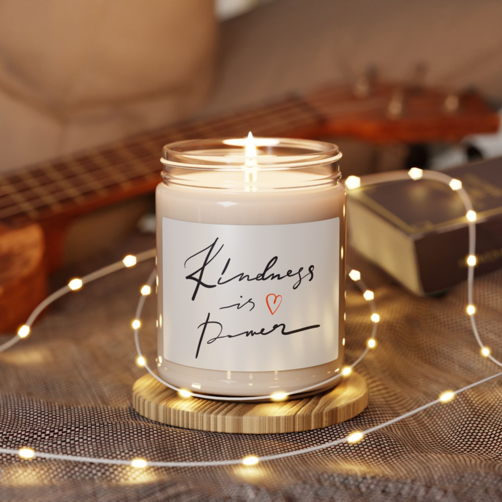 A custom eco-friendly print-on-demand soy candle with a “Kindness is power” sticker.