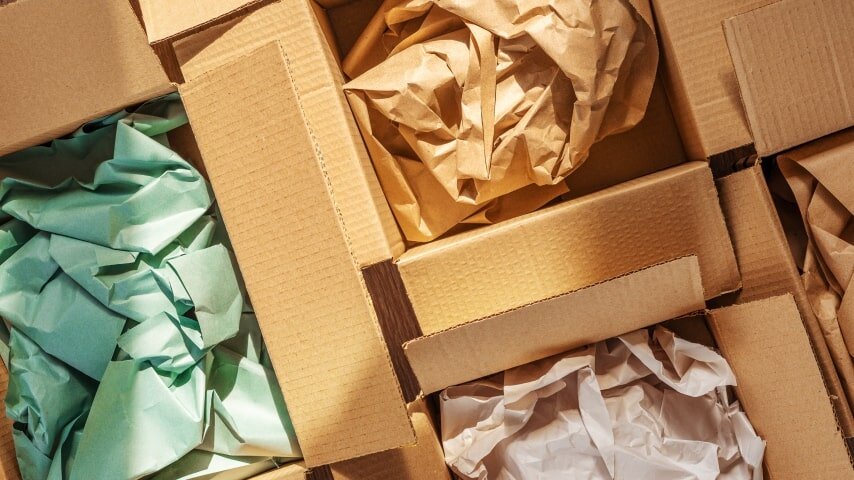 Several boxes filled with colorful wrapping paper for padding.