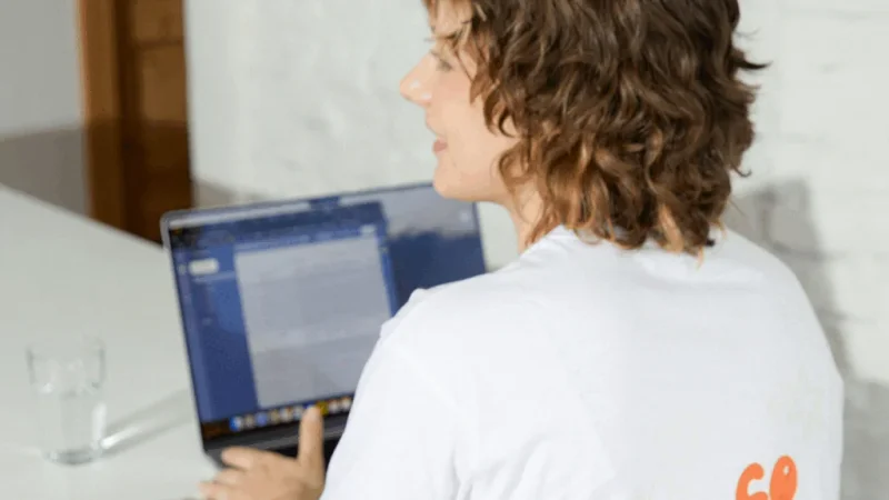 A young woman is using a laptop to learn how to start dropshipping for free.