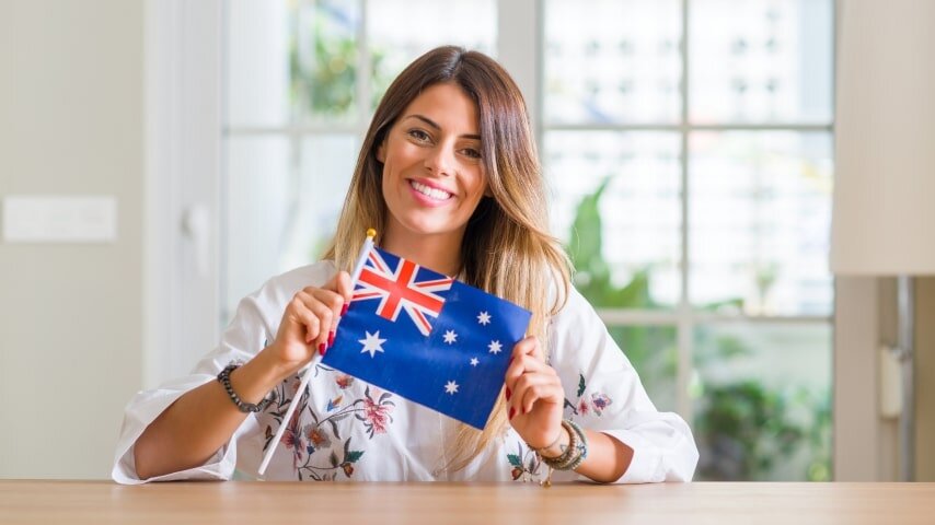 Smiling businesswoman holding an Australian flag.