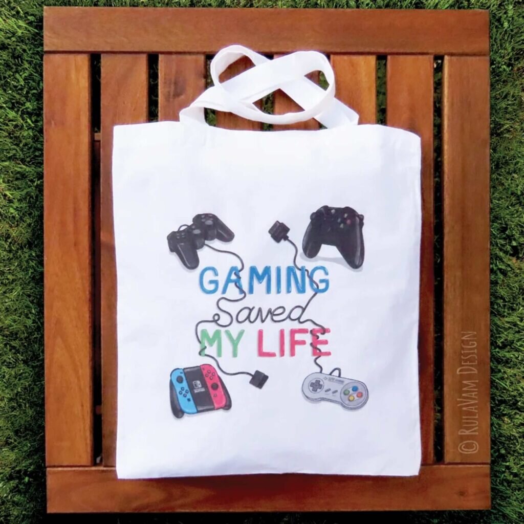 A tote bag with gaming controllers and the text “Gaming saved my life.”