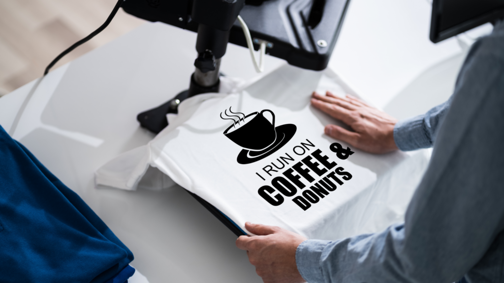 A person displays a t-shirt featuring the words "coffee" and "doughnuts" prominently printed on the front.