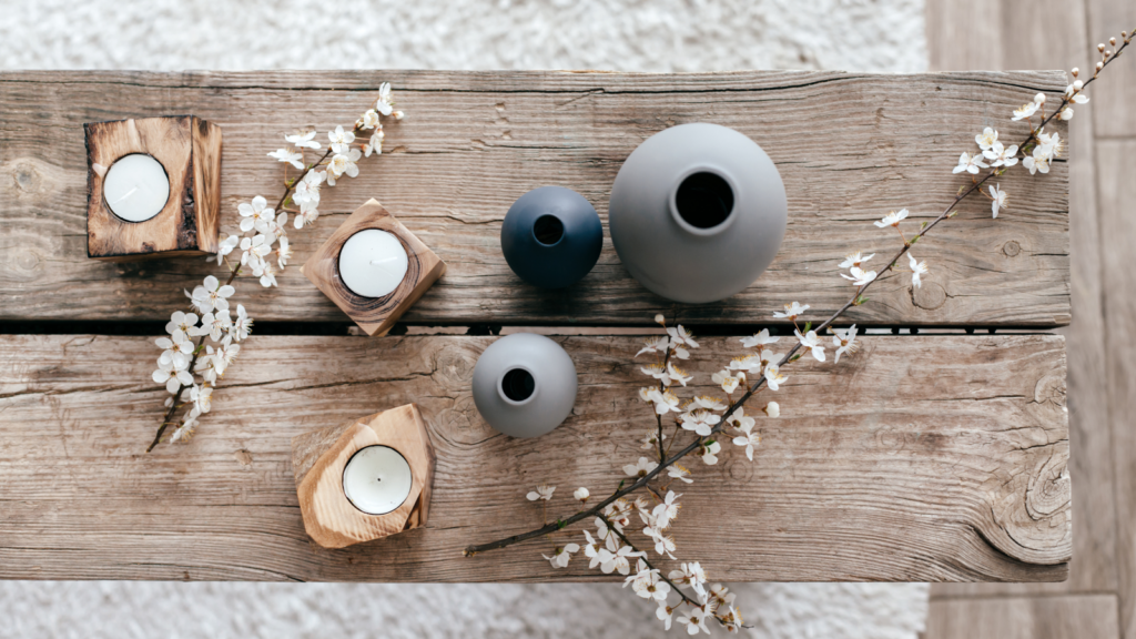 A wooden table adorned with candles and a bouquet of flowers, creating a warm and inviting atmosphere.