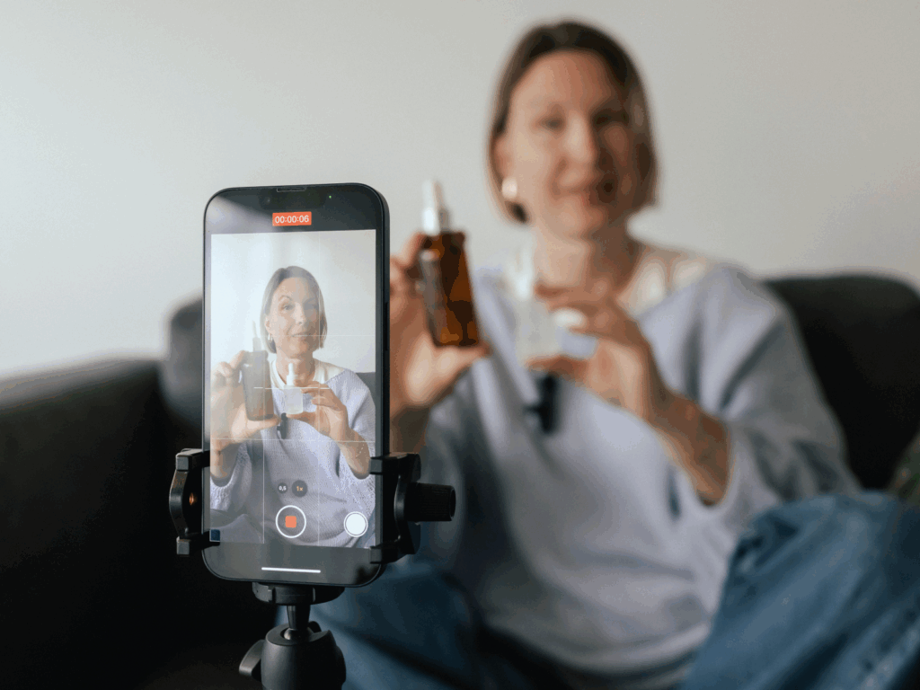 A woman is recording a product presentation video using a mobile phone.