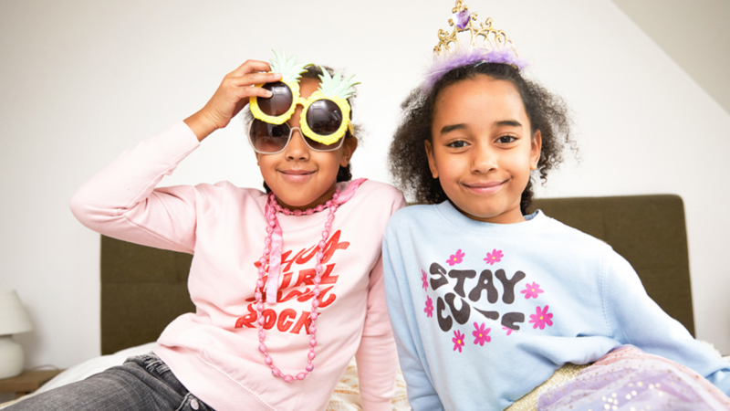 Two kids wearing custom sweatshirts as an example of what to sell on Shopify.