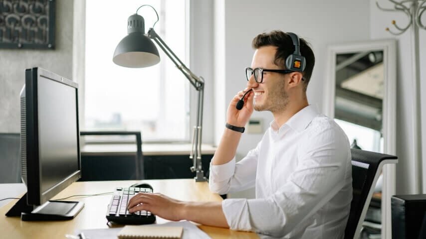 A man wearing a headset and speaking with his Etsy customers.