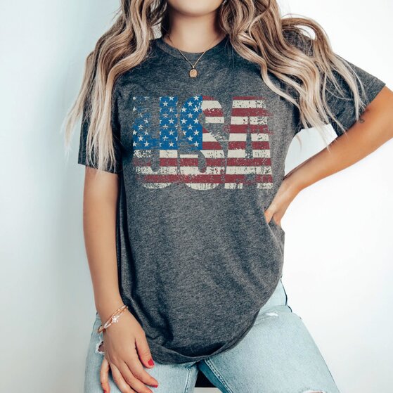 White vintage 4th of July-themed t-shirt with stars and a toy bear.