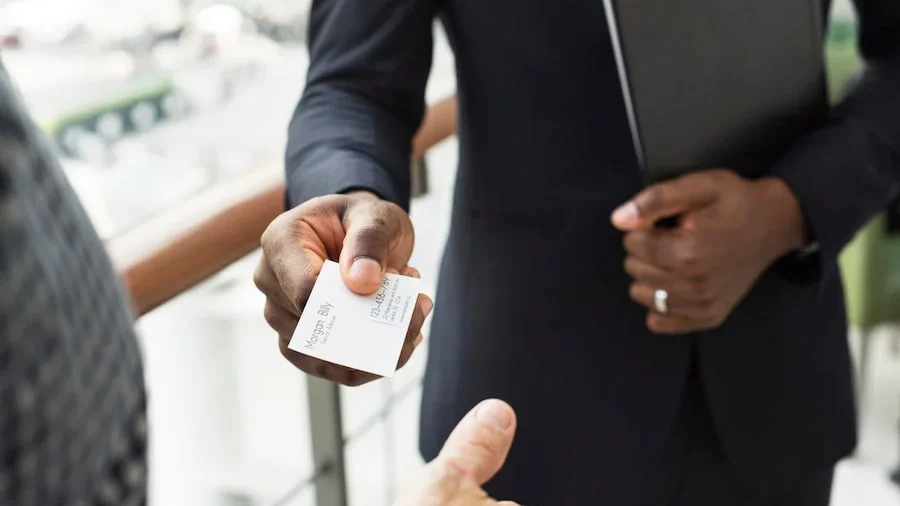 A person giving a business card to another person.