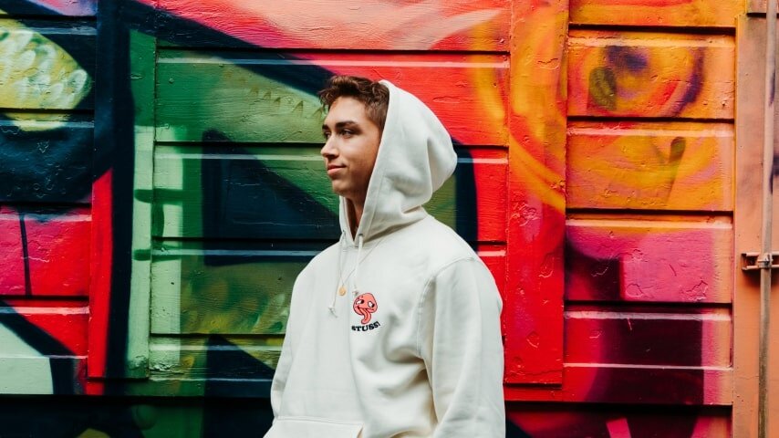 A man is wearing a custom white hoodie.