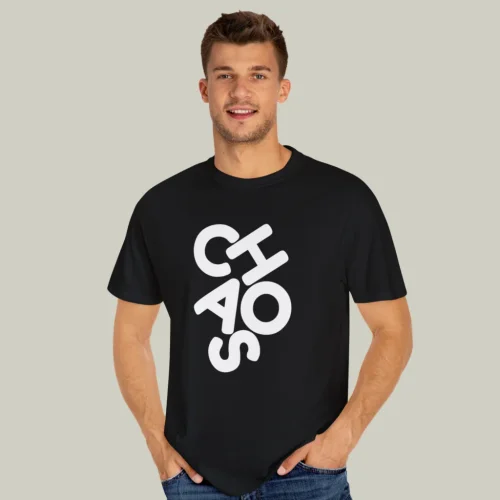A man wearing a black and white “Chaos” t-shirt on a light olive green background.