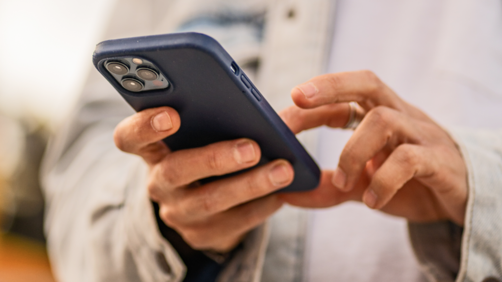 A close-up shot of a person holding a blue smartphone.