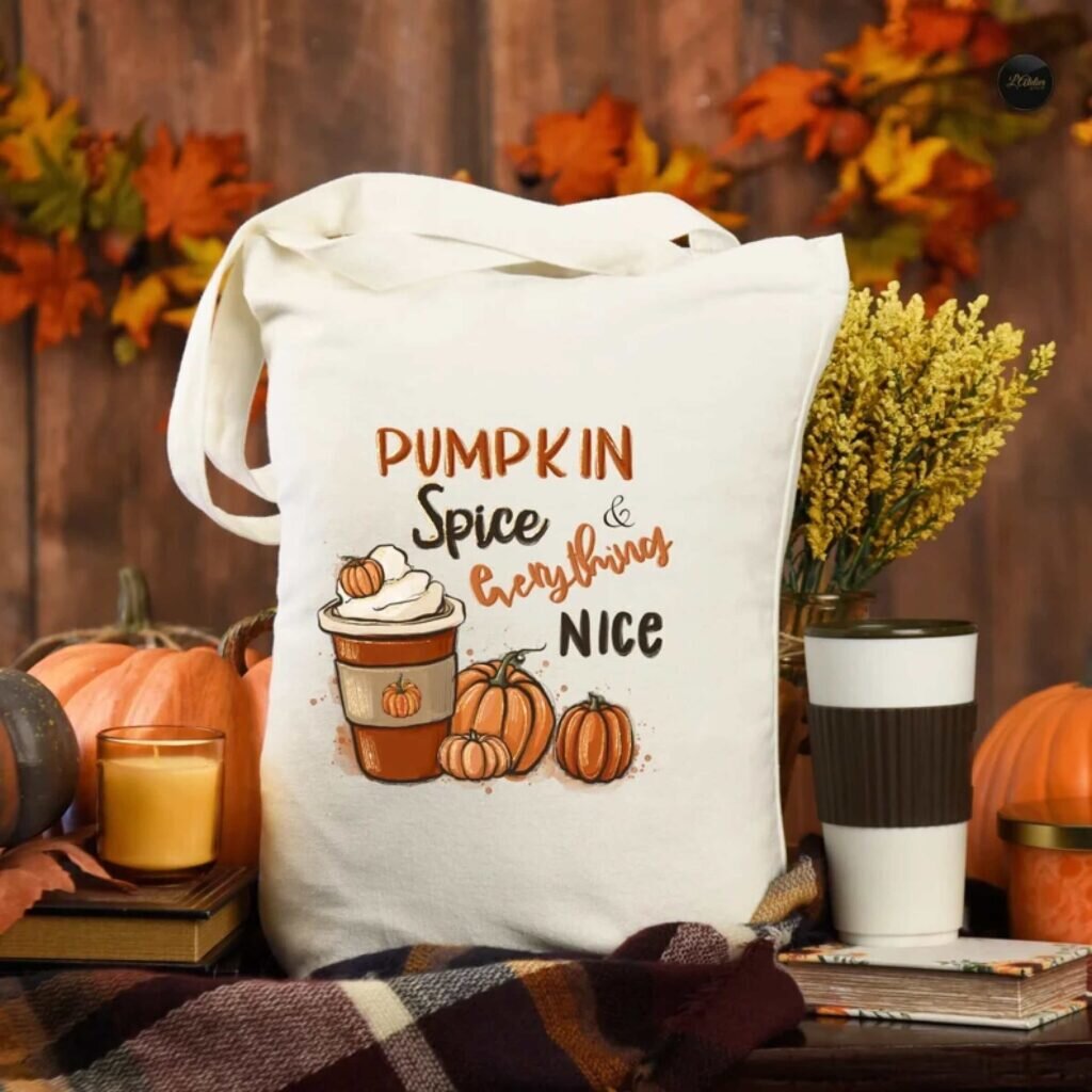 A tote bag with a design of a pumpkin spice latte and the text “Pumpkin spice and everything nice.”