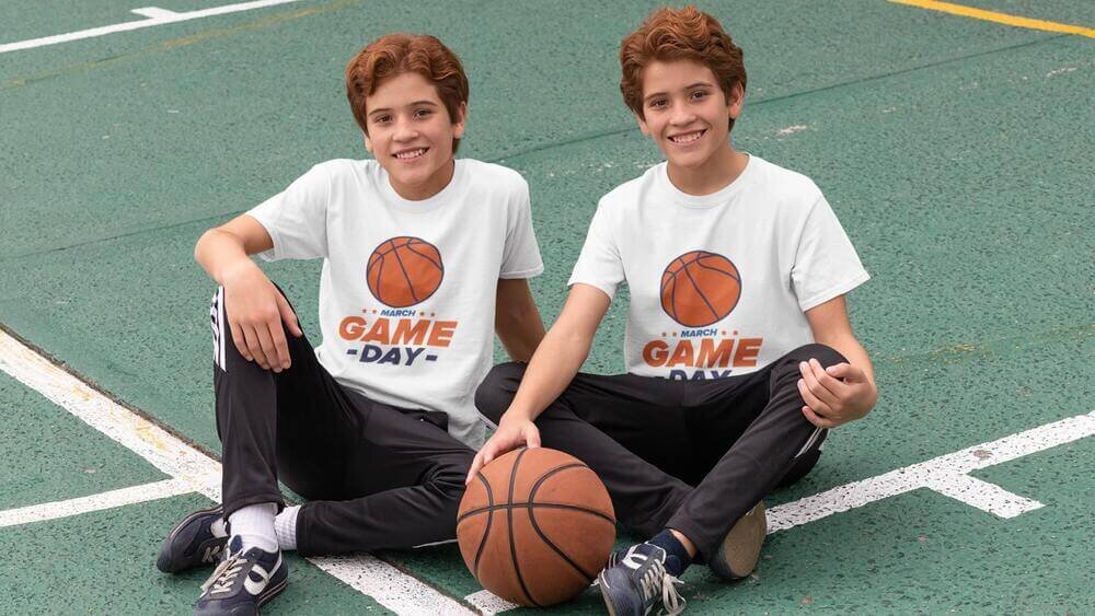 Twins wearing Gildan 64000B kids t-shirts in black, with a basketball-themed print.