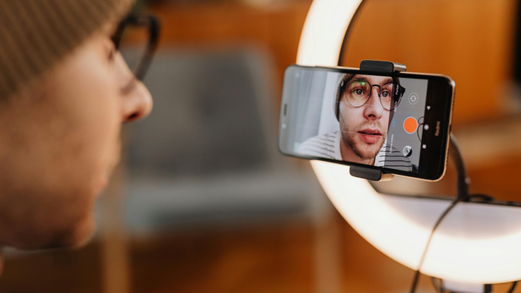 A close-up shot of a man’s face on a mobile phone screen.