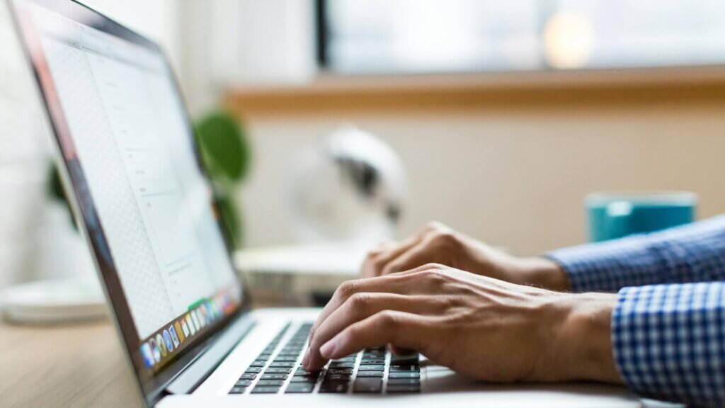 Hands on a laptop keyboard.