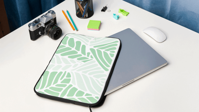 A laptop cover featuring a green leaf pattern.