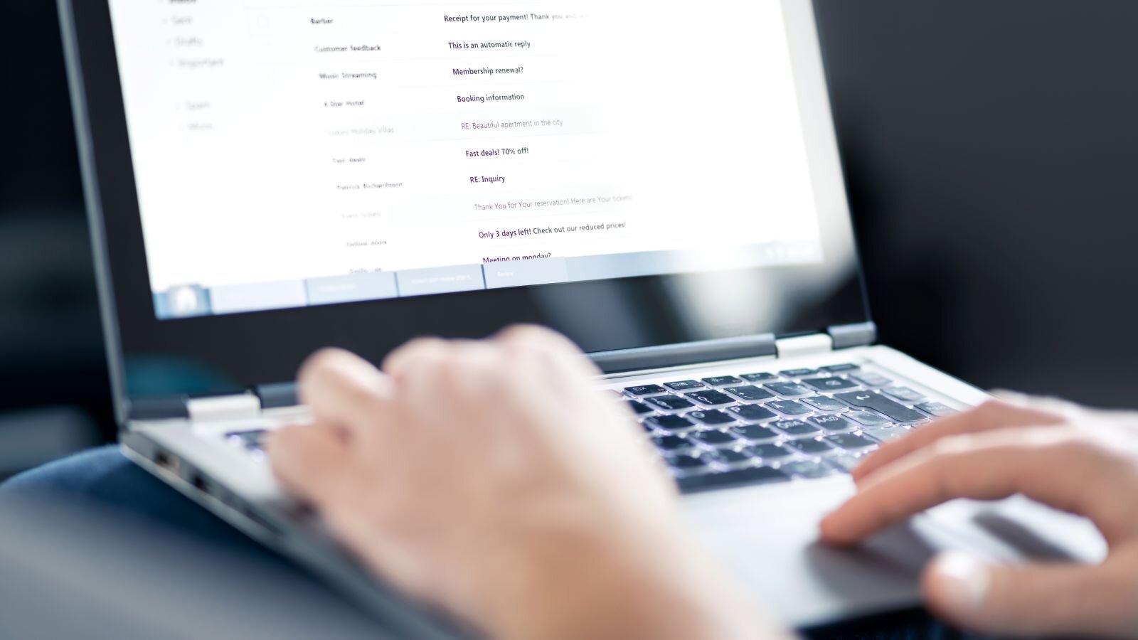 A person typing on a laptop keyboard.