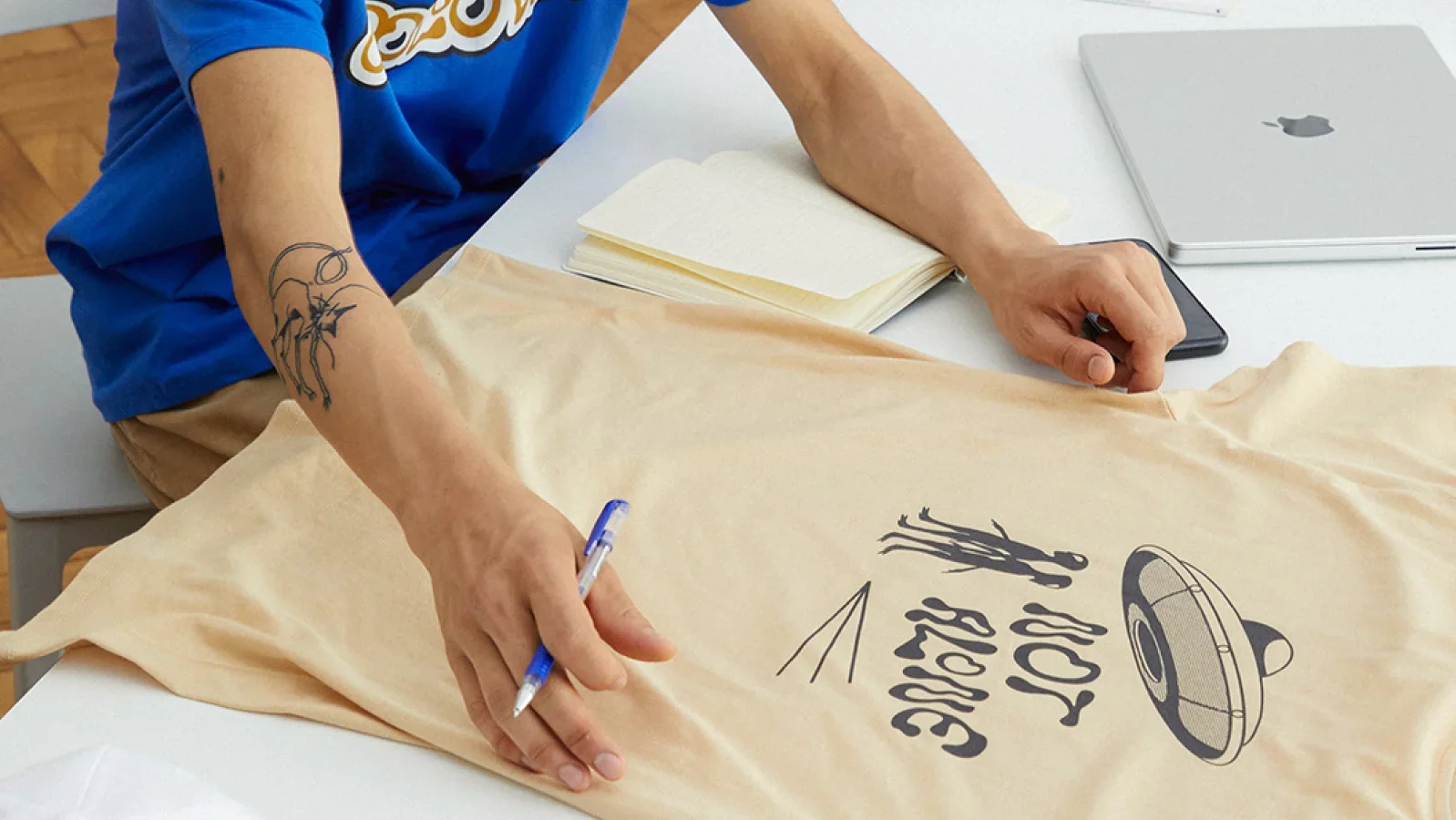 A man examining a custom t-shirt on top of a table.