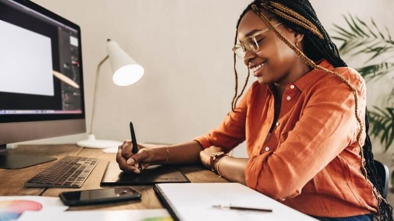 A woman learning how to design a hoodie on her computer.