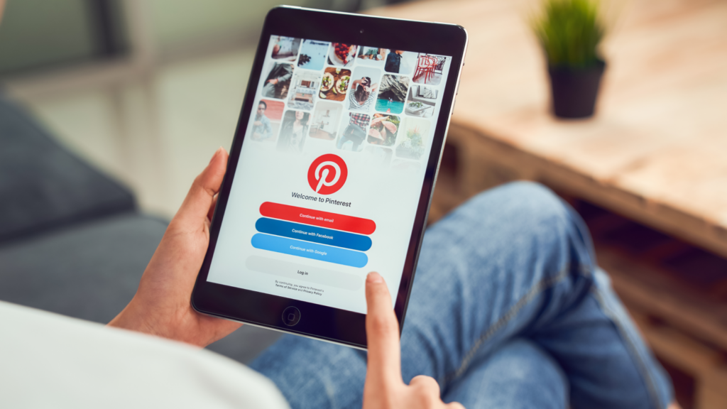 A person holding a tablet and using Pinterest.