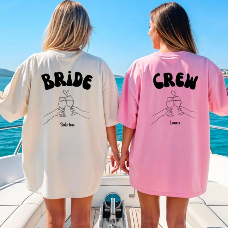 Two women wearing matching shirts that read "Bride Crew," smiling and celebrating together.