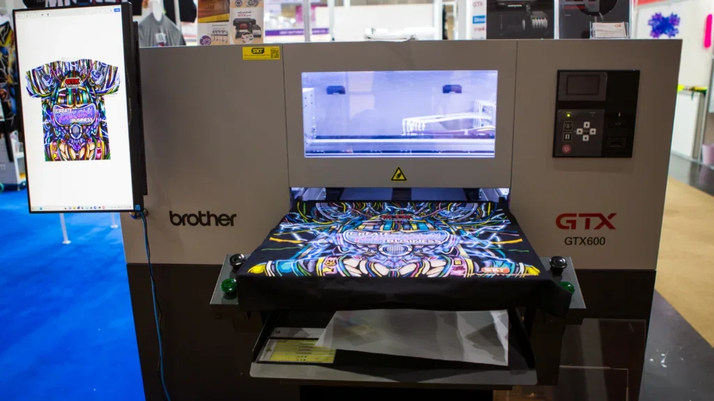 An all-over-print (AOP) t-shirt is being printed using a sublimation printer.