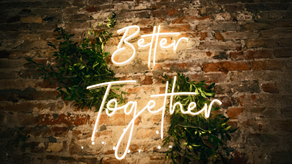 Neon sign displaying the phrase "Better Together" in bright colors against a dark background.