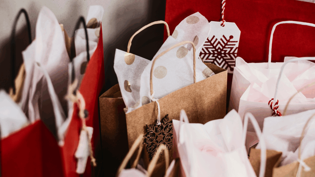 A room filled with numerous bags of Christmas gifts, creating a festive and cheerful atmosphere.