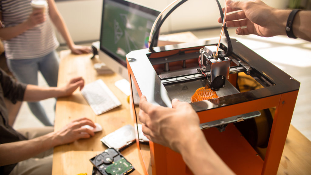 A group of people using a 3D printer.