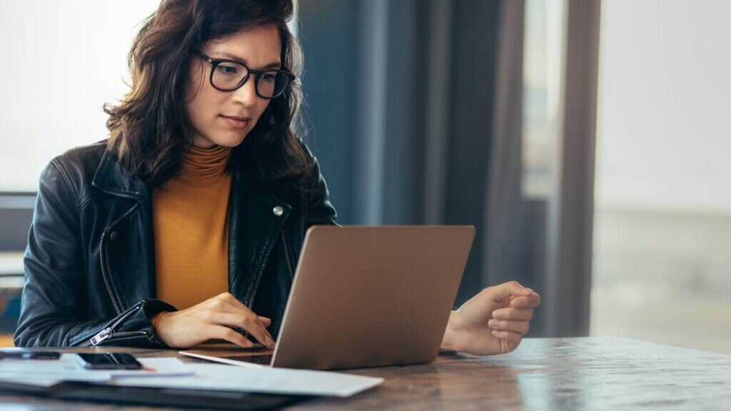 A woman looking at a laptop screen.