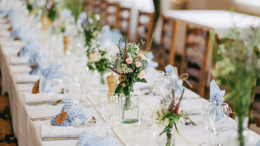 A long table covered with blue and white tablecloths, elegantly set for a gathering or event.