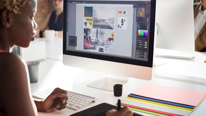 A graphic designer creating designs for Shopify phone cases on her computer.