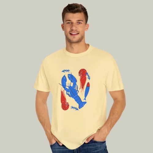 A man wearing a red, blue, and yellow custom t-shirt on a light olive green background.