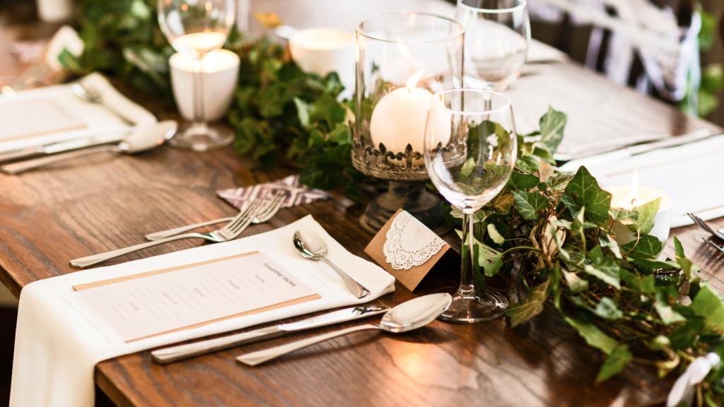 A beautifully set table with elegant place settings and flickering candles, creating a warm and inviting atmosphere.
