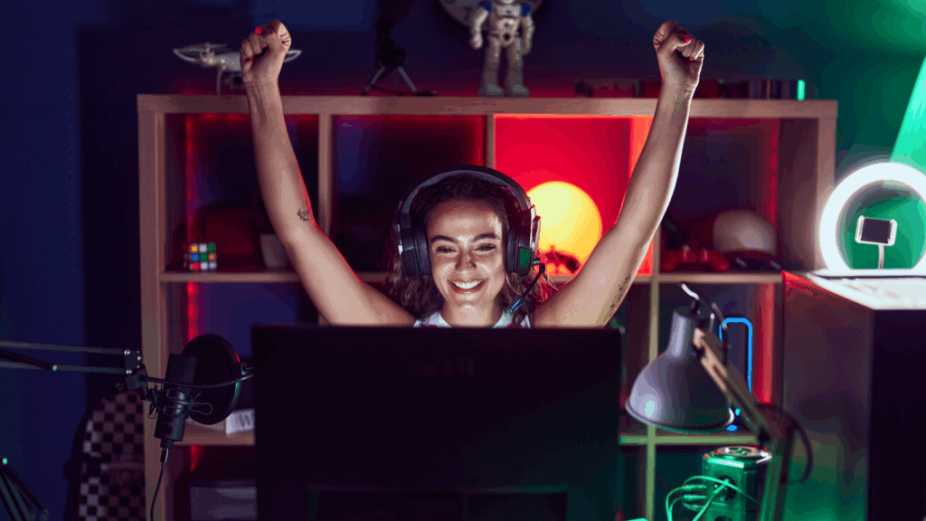 A woman wearing headphones sits at a laptop, focused on her work in front of a computer screen.