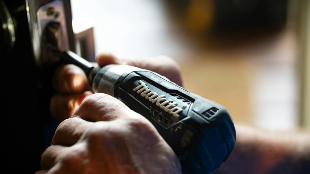 A person holding a power tool.