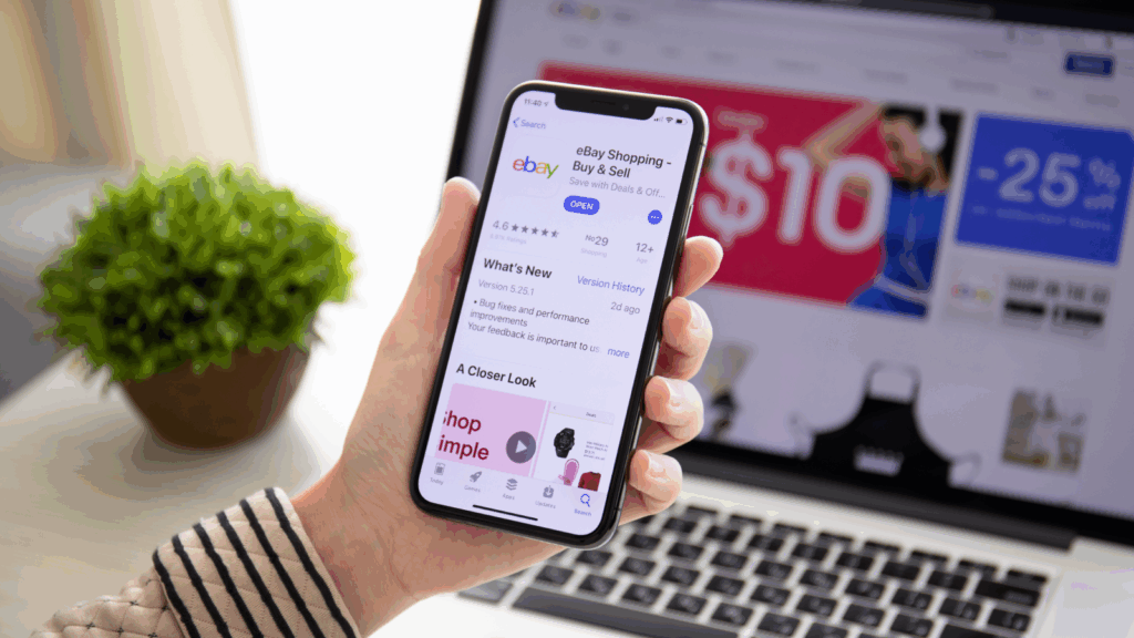A person holding a phone with an eBay app on it.