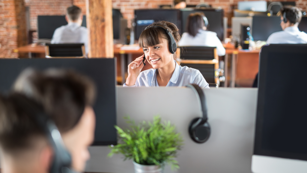 A woman with headphones on, engaged in her tasks within a professional office setting.
