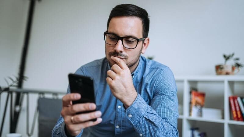 A man using the TikTok app on his phone.