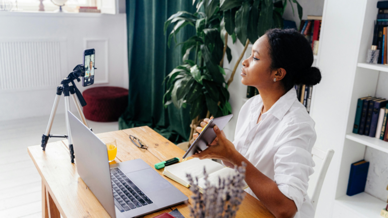 A woman showcasing products and using her phone to live stream.