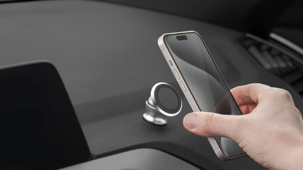 A person placing their phone on a phone holder in their car.