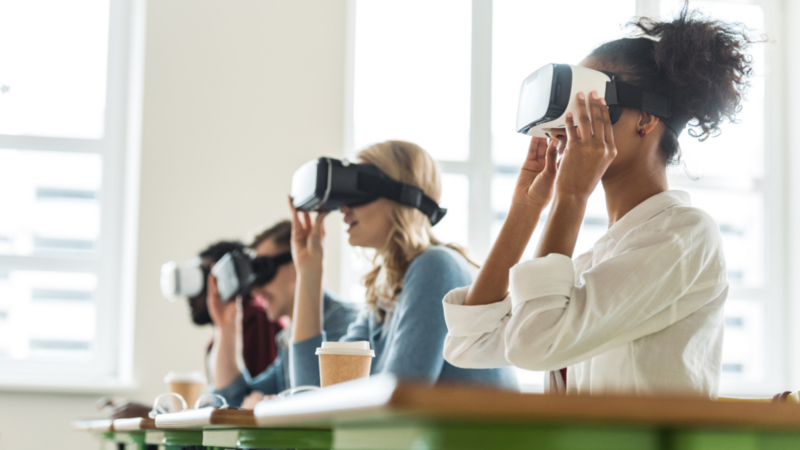 A diverse group of individuals engaged in an immersive experience, all wearing virtual reality glasses.