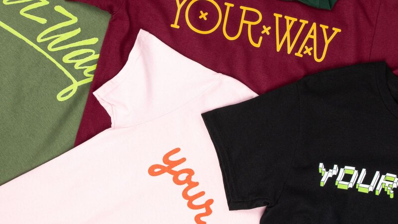 A collection of t-shirts in different colors, each featuring the phrase "YOUR WAY" in various styles and fonts.