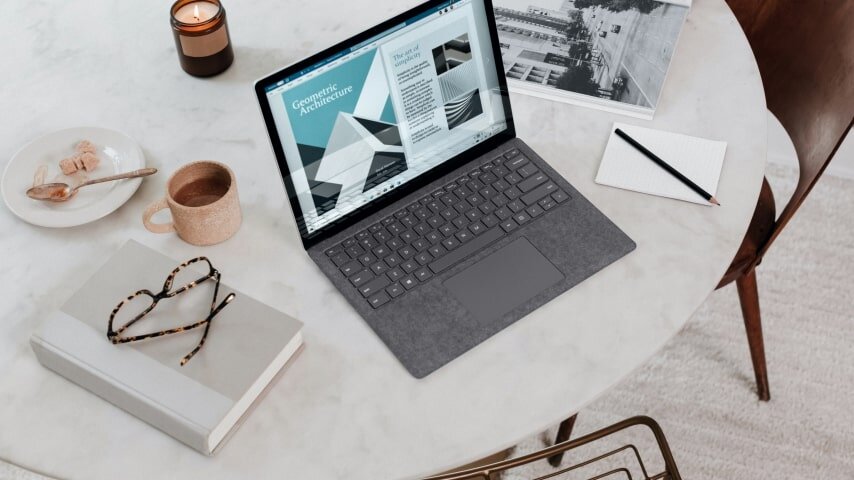 A laptop on the table with other accessories next to it.
