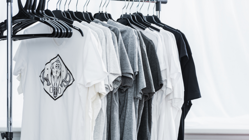 A rack displaying various t-shirts neatly hung on hangers, showcasing different colors and styles.
