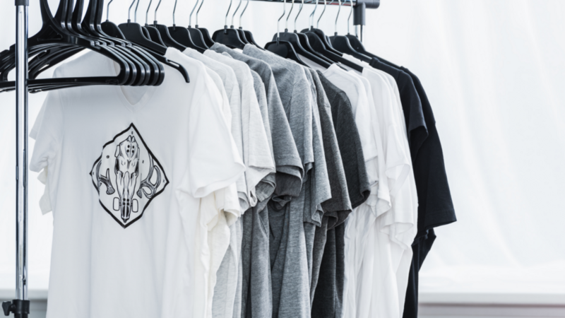A rack displaying various t-shirts neatly hung on hangers, showcasing different colors and styles.