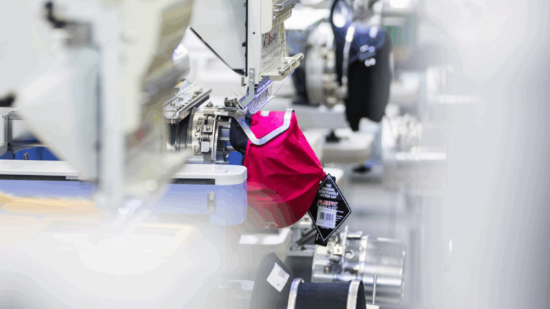 A red bag is hanging on a machine in a factory setting.