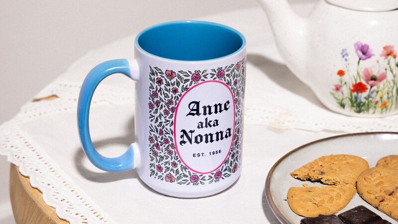 A coffee mug and coaster featuring the word "salut" elegantly displayed on a wooden surface.