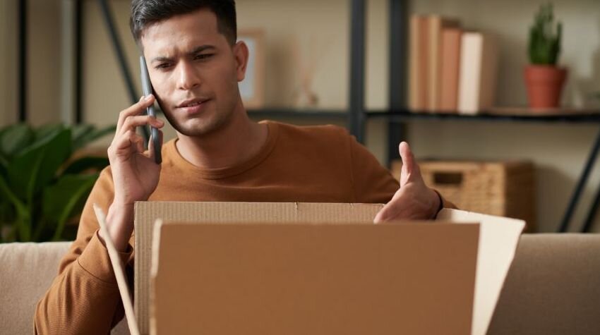 Man speaking on the phone about a delivered package he is not happy with.
